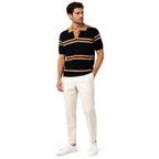 WEELZ black and tan striped V-neck knit polo worn with cream tailored trousers